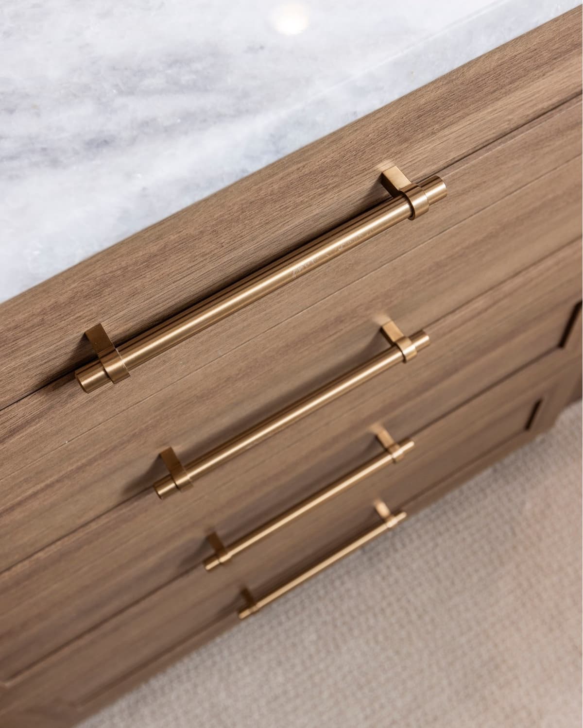 Walnut drawer detail with brass hardware and marble top